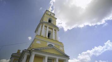 pittoresk se av ortodox kyrka med en lång gul och vit torn. klämma. skön kristen kyrka på bakgrund av blå himmel i sommar. foto