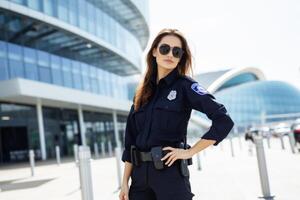 ai genererad porträtt kvalificerad självsäker sträng ung europeisk kvinna lady kvinna polis officer medlem säkerhet krafter Framställ enhetlig solglasögon stadens centrum urban. kriminell rättvisa patrullera service lag foto