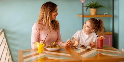 mor och dotter har en frukost med färsk pressas juicer i de Kafé foto