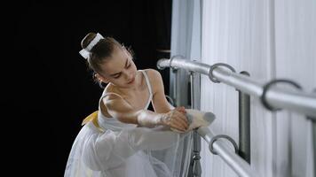 tonåring caucasian ballerina flicka tonåring dansare barn studerande i dansa hall håller på med koreografiska övning på dansa skola klass nära balett barre stretching känsla fot smärta knä skada sträcka problem foto