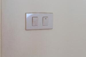 vit elektrisk växla tallrik på de vägg för kontrollera de ljus vändning på eller av foto