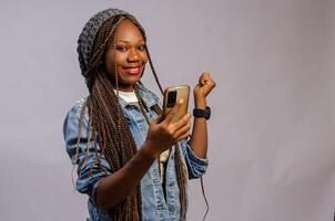 afrikansk lady bär en tillfällig trasa känsla upphetsad handla om Vad hon fick syn på på henne telefon foto