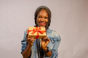 flicka leende som hon innehar en gåva i henne foto