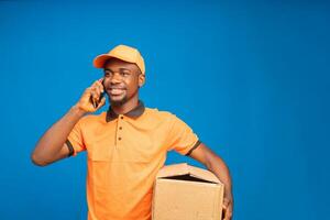 afrikansk leverans man framställning samtal med hans mobiltelefon isolerat över blå bakgrund foto