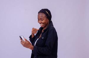 skön ung afrikansk lady pekande till henne telefon skärm i spänning foto