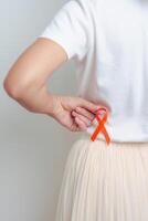 kvinna har tillbaka buk smärta med orange band. njure cancer medvetenhet Mars månad, sjukdom av urin- systemet och stenar, cancer, kronisk njure, urologi, njur- och transplantation begrepp foto