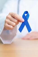 Mars kolorektal cancer medvetenhet månad, läkare med mörk blå band för stödjande människor levande och sjukdom. sjukvård, hoppas och värld cancer dag begrepp foto