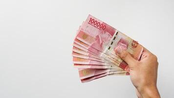 hand innehav indonesiska rupiah pengar. indonesiska valuta foto