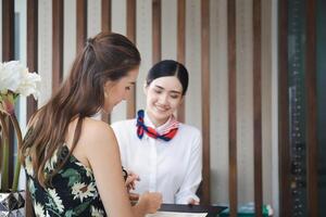 fokus på kvinna resenärer med väska resa bagage checka in på de hotell med suddig leende kvinna receptionist foto