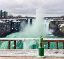 ai genererad grön läppstift på de bakgrund av de niagara falls i vinter. foto