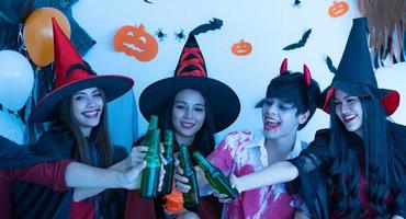 asiatiska unga människor i kostymer delta fira på halloween fest foto
