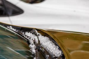 små hagel is bollar på brun bil huva efter tung sommar storm foto