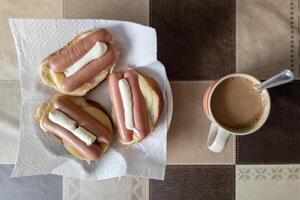 varm smörgåsar med ost, korvar och majonnäs med kopp av kaffe med mjölk foto