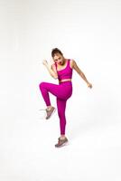 kvinna i vibrerande rosa sporter utrusta med ett böjd ben och ärm foto