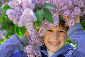 en Pojkar ansikte i blomning vår syrener. barn på en vår promenad. vår kom. foto