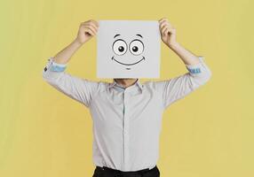 ung affärsman innehav vit kort med en Lycklig ansikte på den isolerat på gul bakgrund foto