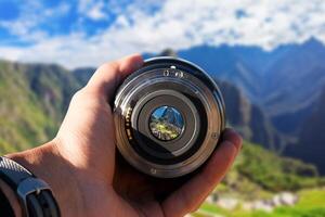 selektiv fokus skott person innehav kamera lins på machu picchu turist tar en bild med kamera lins på machu picchu foto