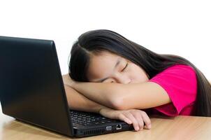 ung söt flicka asiatisk sovande flicka på de tangentbord foto