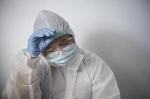 under de covid-19 pandemisk, ett asiatisk kvinna läkare var överarbetad, som vänster henne utmattad och bekymrad. foto