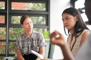 olika anställda samlade in i kontor har roligt under brainstorming medan diskuterar ny idéer projekt. raser medarbetare möte på coworking Plats område. team av ung människor i kontor. foto