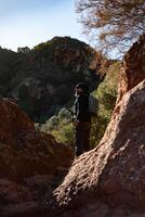 medelålders man överväger de landskap av de garraf naturlig parkera medan gående längs de spår av en berg. foto