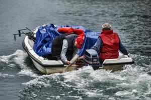 lugo, galicien, spanien, 2021 - transporterar lådor med druvor nerför floden i en motorbåt från vingården till traktorn foto