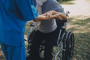 ung asiatisk fysisk terapeut arbetssätt med senior kvinna på gående med en rollator foto