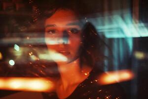 ai genererad porträtt av en skön ung kvinna i en mörk rum med lampor. foto