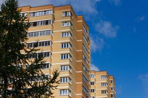 ny hög stiga tegel lägenhet byggnader med gran träd foto
