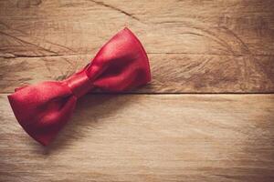 röd rosett slips placerad på trä- golv. foto