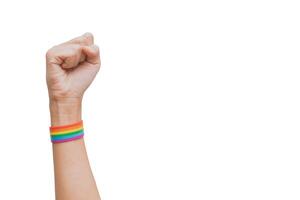 näve med en Uppfostrad hand regnbåge flagga handledsband på en vit bakgrund. Gay rättigheter bekämpa. Gay stolthet HBTQ begrepp foto