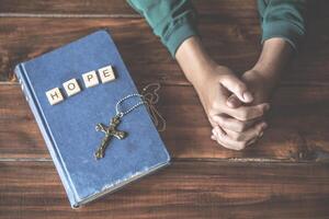 kristen händer är bön- och bön- till Gud. med en bibel bok placerad på de sida och ha de brev hoppas foto