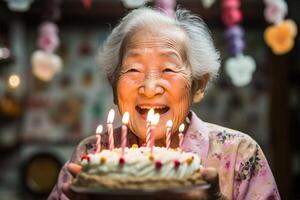 ai genererad ett äldre asiatisk kvinna slag ut ljus på en födelsedag kaka i henne Hem foto