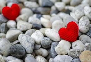 hand tillverkad virka sticka röd hjärta form på sten bakgrund. valentines dag begrepp. kopia Plats. foto