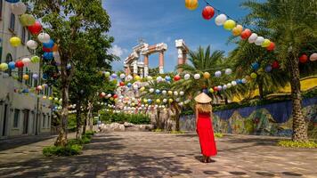 kvinna i röd klänning och vietnamese hatt utforska solnedgång stad på phu quoc ö foto