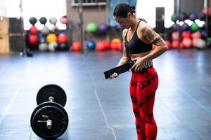 stark kvinna framställning till tyngdlyftning i en korsa Träning Gym foto