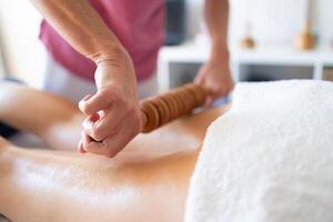 beskära osteopat håller på med trä terapi massage på klient foto