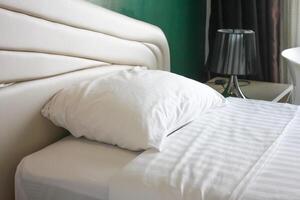 interiör av en hotell sovrum med vit säng och vit tabell lampa foto