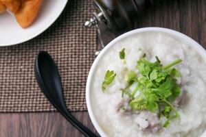 stänga upp ris gröt , congee med mald fläsk och ingefära i vit skål foto