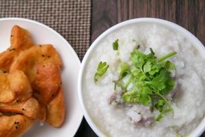 stänga upp ris gröt , congee med mald fläsk och ingefära i vit skål foto