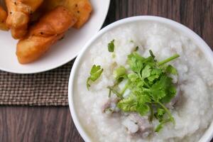 stänga upp ris gröt , congee med mald fläsk och ingefära i vit skål foto