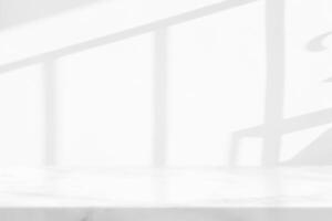 marmor tabell med vit stuck vägg textur bakgrund med ljus stråle och skugga från de fönster, lämplig för produkt presentation bakgrund, visa, och falsk upp. foto