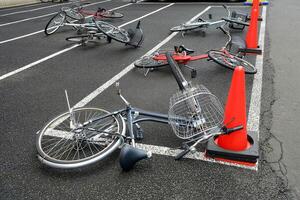 faller cyklar på de parkering i blåsigt dag. foto