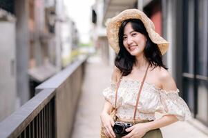 Lycklig ungdom asiatisk kvinna med kamera resor gata stad resa på fritid helgen. ung hipster kvinna turist sightseeing sommar urban bangkok destination. Asien sommar turism begrepp. foto