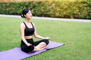 wellness fly. asiatisk kvinna yoga entusiast omfamnar lugn, ansluter kropp och anda i en frodig, fredlig djungel miljö. foto