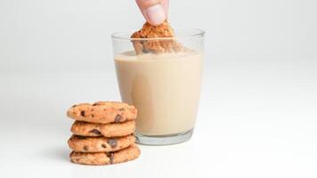choklad chip småkakor och en glas av mjölk kaffe på en vit bakgrund foto