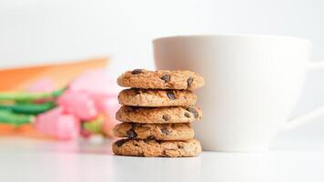 choklad chip småkakor och en glas av mjölk kaffe på en vit bakgrund foto