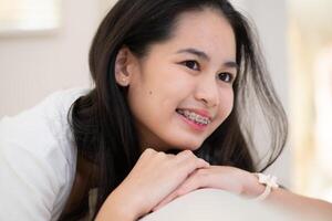 porträtt av en ung asiatisk kvinna med tandställning på henne tänder foto