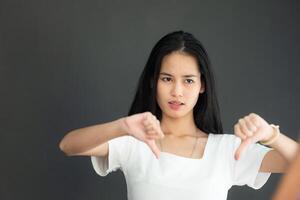 porträtt av asiatisk ung kvinna i tom vit t-shirt på svart bakgrund foto