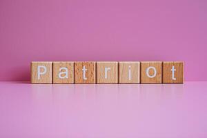 trä- block form de text patriot mot en rosa bakgrund. foto